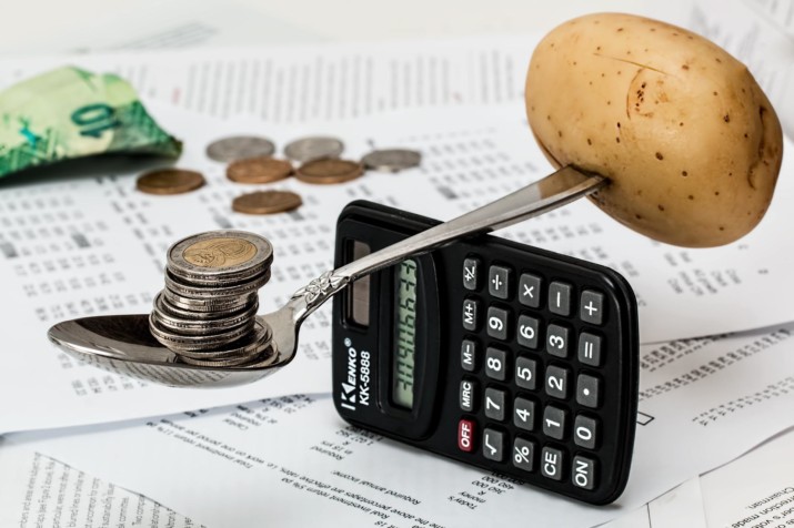 potato against coins on the weights